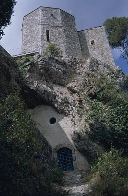 Absis del santuari sobre la roca, amb l'entrada de la cova al peu