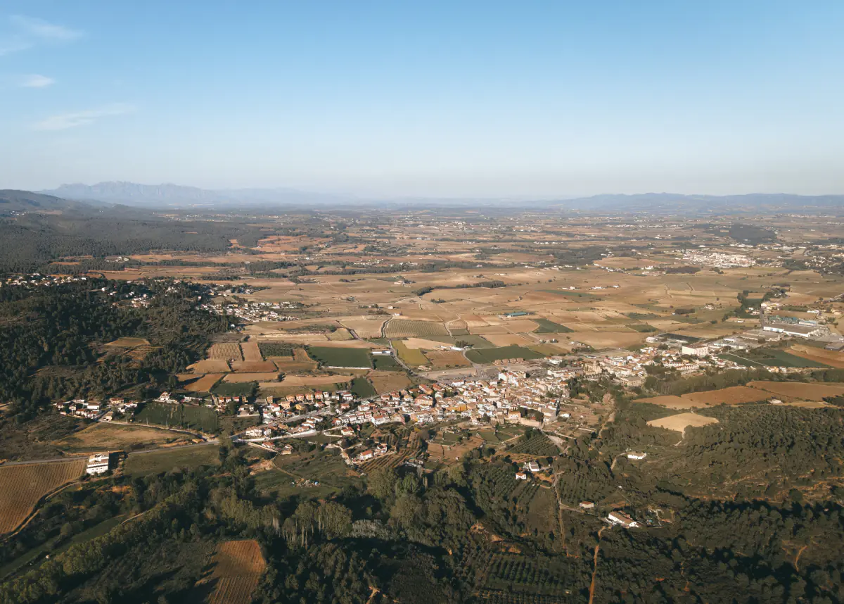 El terme de Torrelles de Foix des de l'aire, amb la serra de Montserrat a l'horitzó