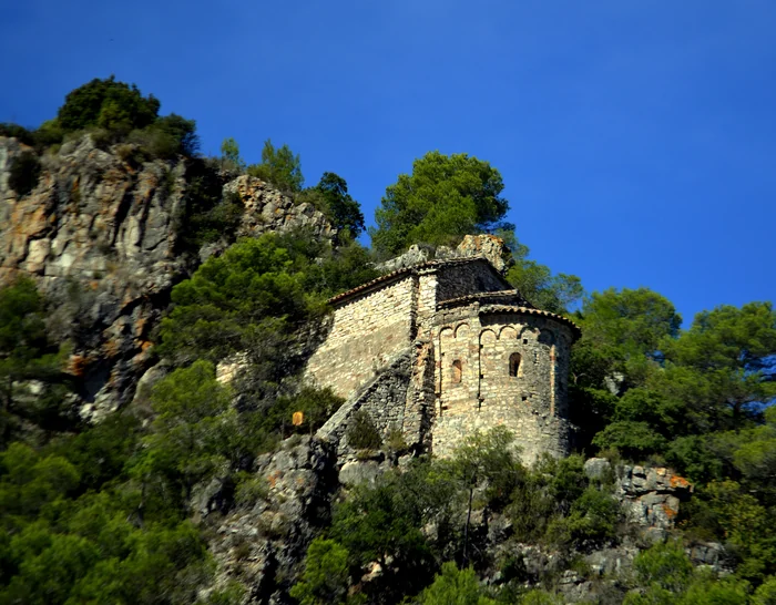 Sant Joan de Pontons, avui Sant Joan de la Muntanya. És la que Castellanos veu «á la vorera oposada», penjada sobre la riera en la cinglera. La va descriure «emblanquinada»: avui la pedra és nua.