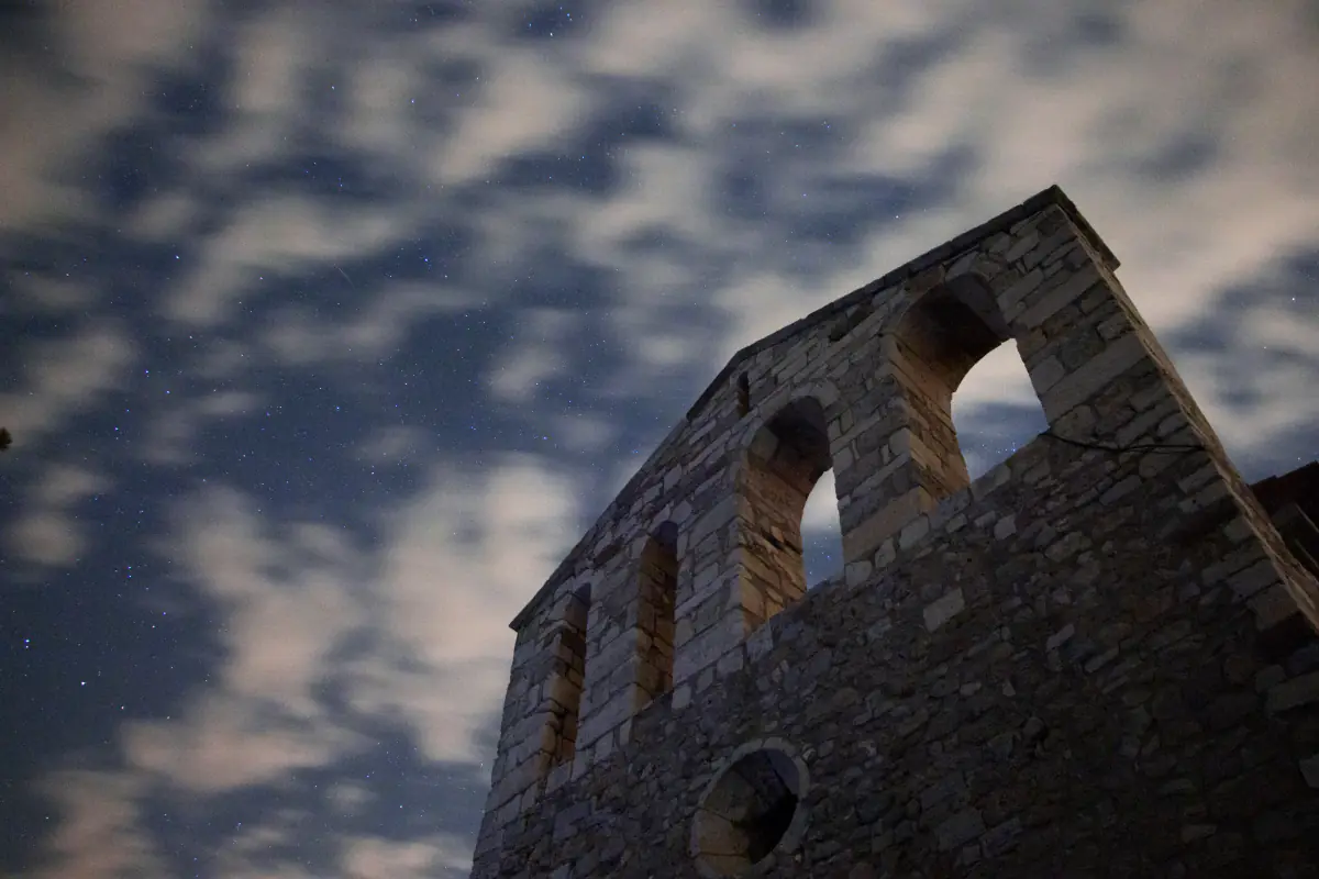 El campanario de espadaña del santuario de Santa Maria de Foix de noche, con el cielo estrellado al fondo